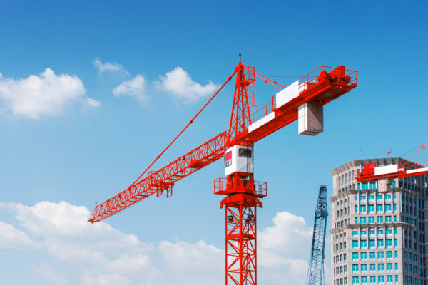 Inside place for tall buildings under construction and cranes under a blue sky