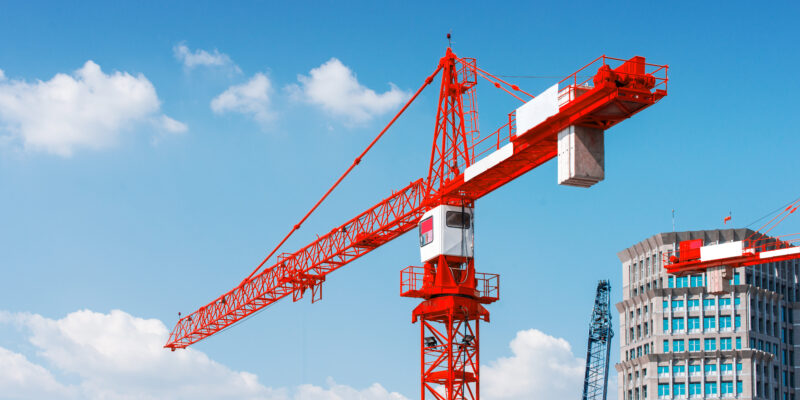 Inside place for tall buildings under construction and cranes under a blue sky