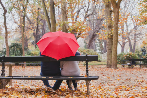 couple under umbrella in autumn park, love concept, happy elderly people