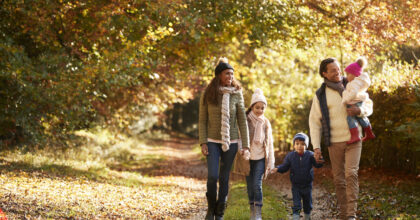 Front View Of Family Enjoying Autumn Walk In Countryside