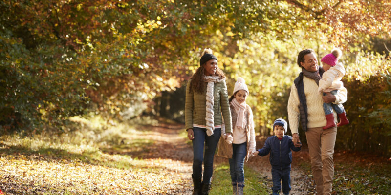 Front View Of Family Enjoying Autumn Walk In Countryside