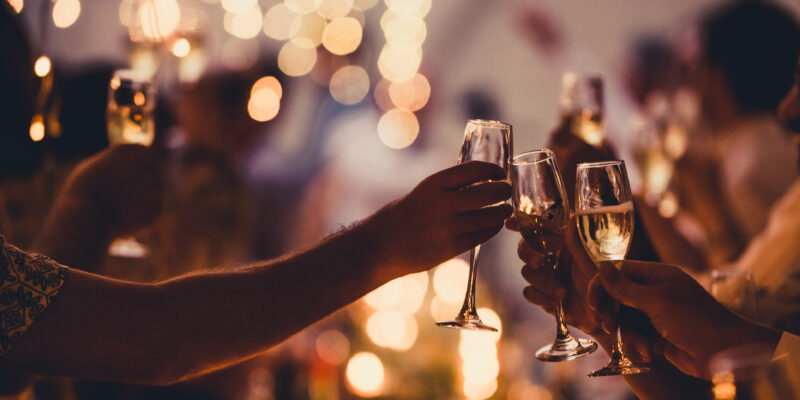 Numerous hands holding champagne flutes with champagne celebratory toast silhouettes